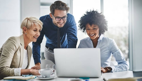 three people looking at a laptop