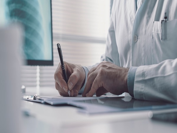 man writing at desk