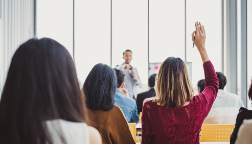 learners raising hand in classroom
