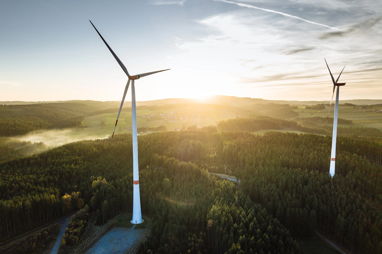 windmill farm with a sunset in the background
