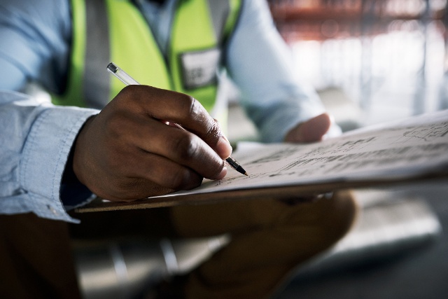man writing something on a piece of paper