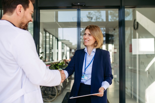 woman shaking medical professional's hand representing contract manufacturers in medtech inductry