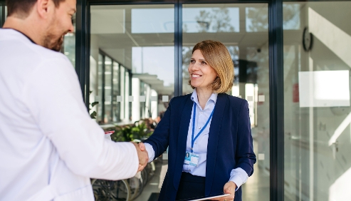 woman shaking medical professional's hand representing contract manufacturers in medtech inductry