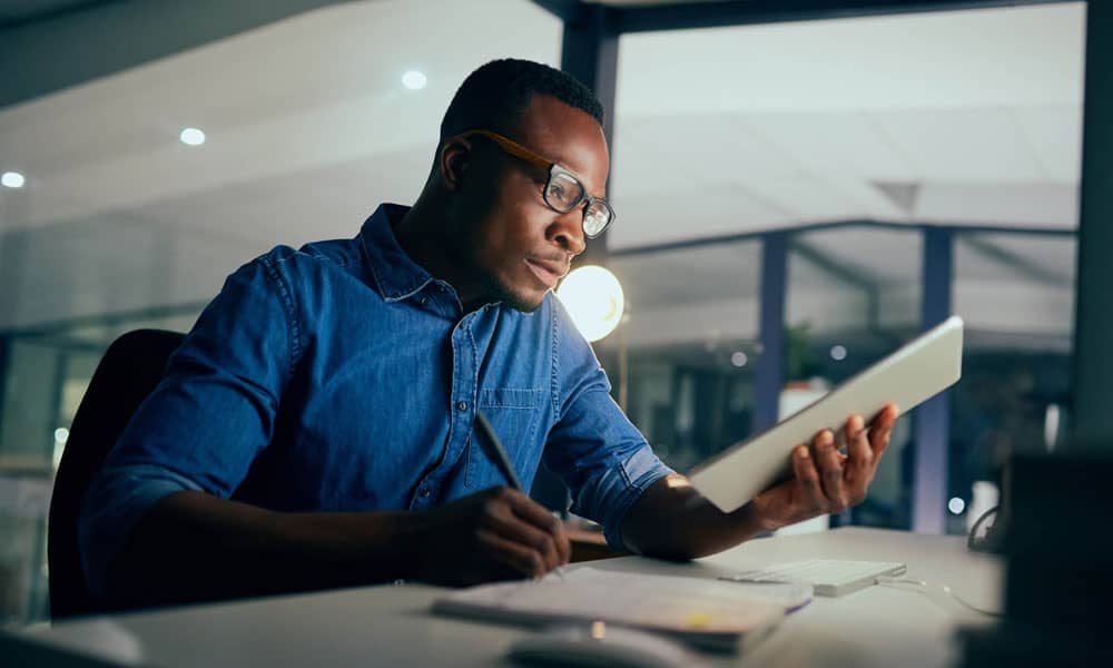 man in an office working looking at ipad