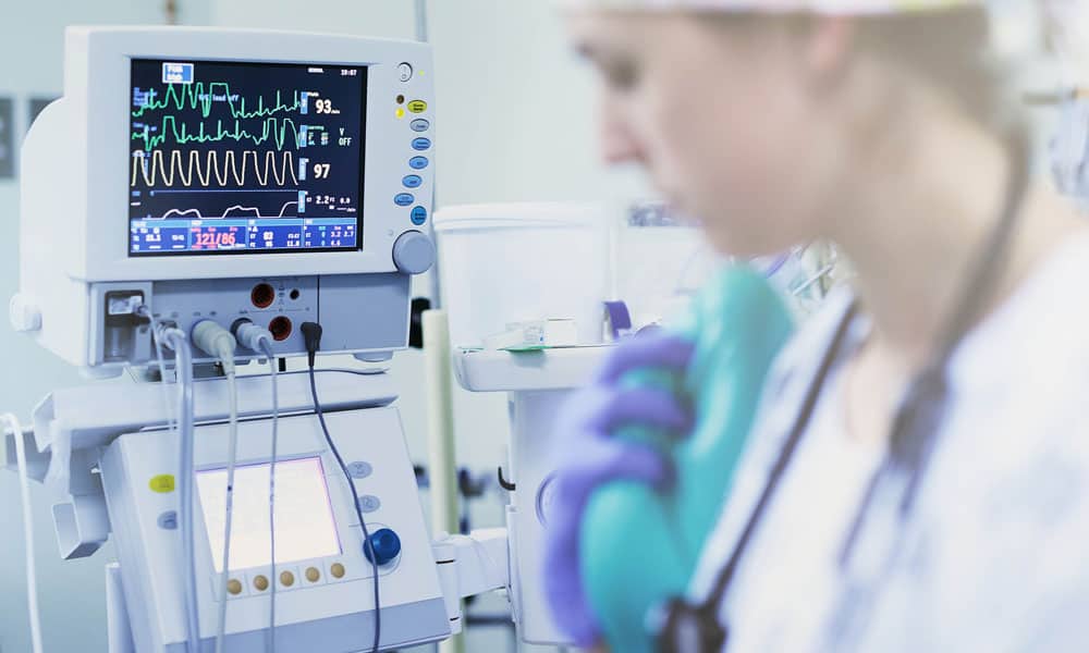 healthcare worker standing next to medical devices