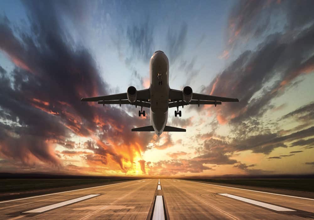 airplane taking off safely in the sunset