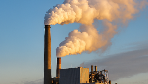 smoke coming out of a manufacturing plant against blue sky