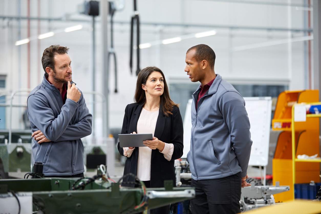 automotive professionals reviewing IATF 16949 certification criteria on a plant floor