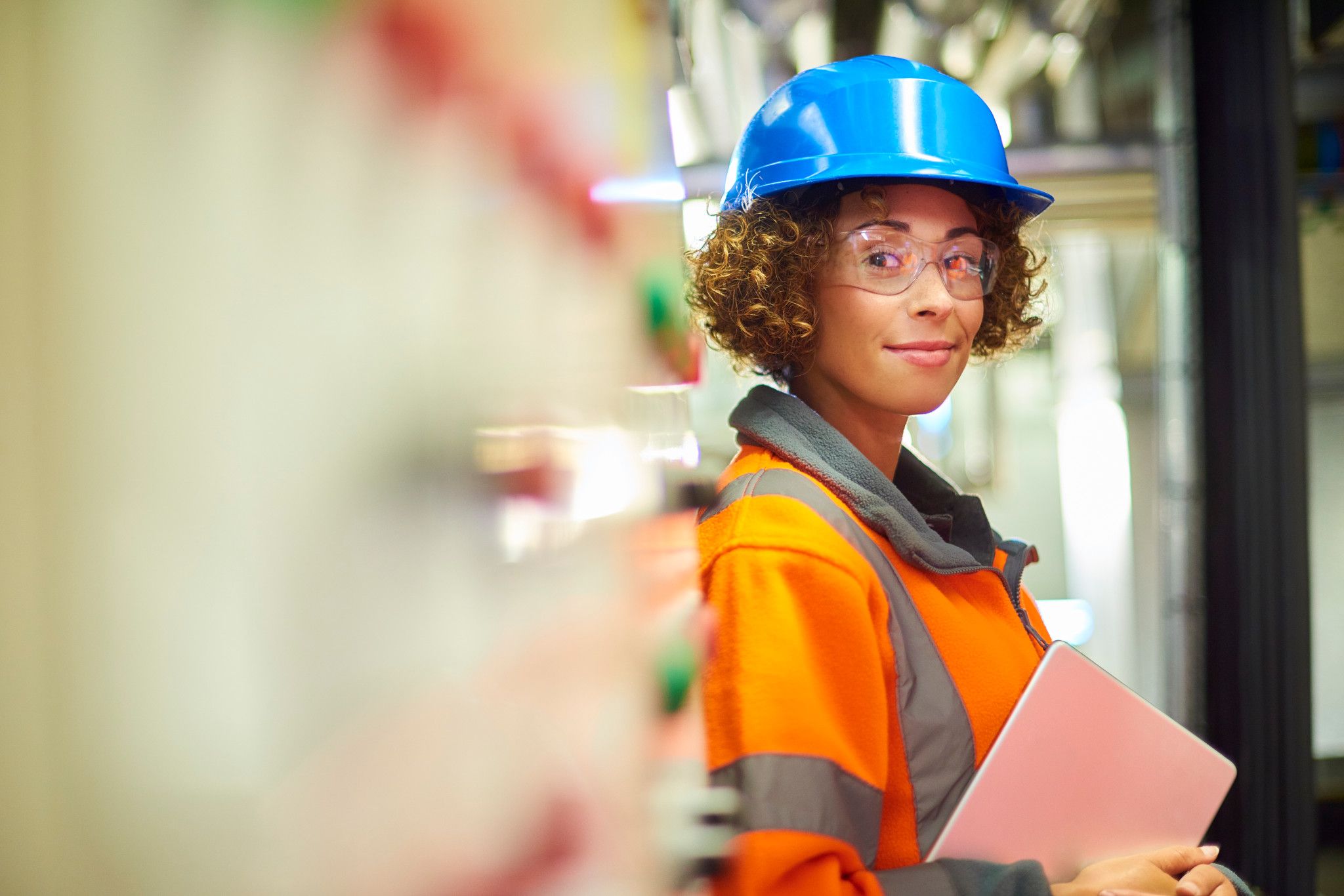 health and safety female professional wearing a blue hat and orange vest