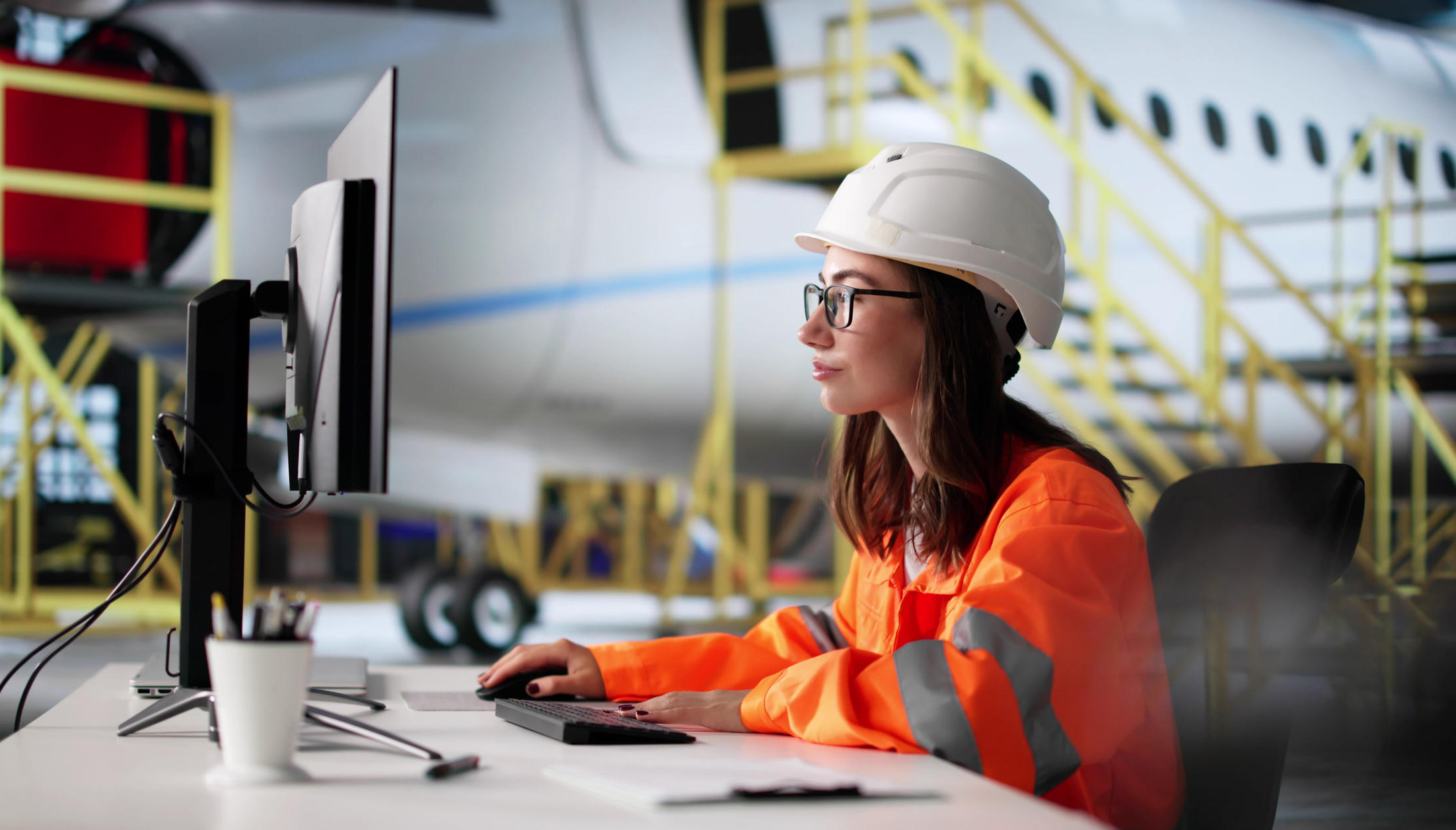 Among the airplanes, woman focused on computer