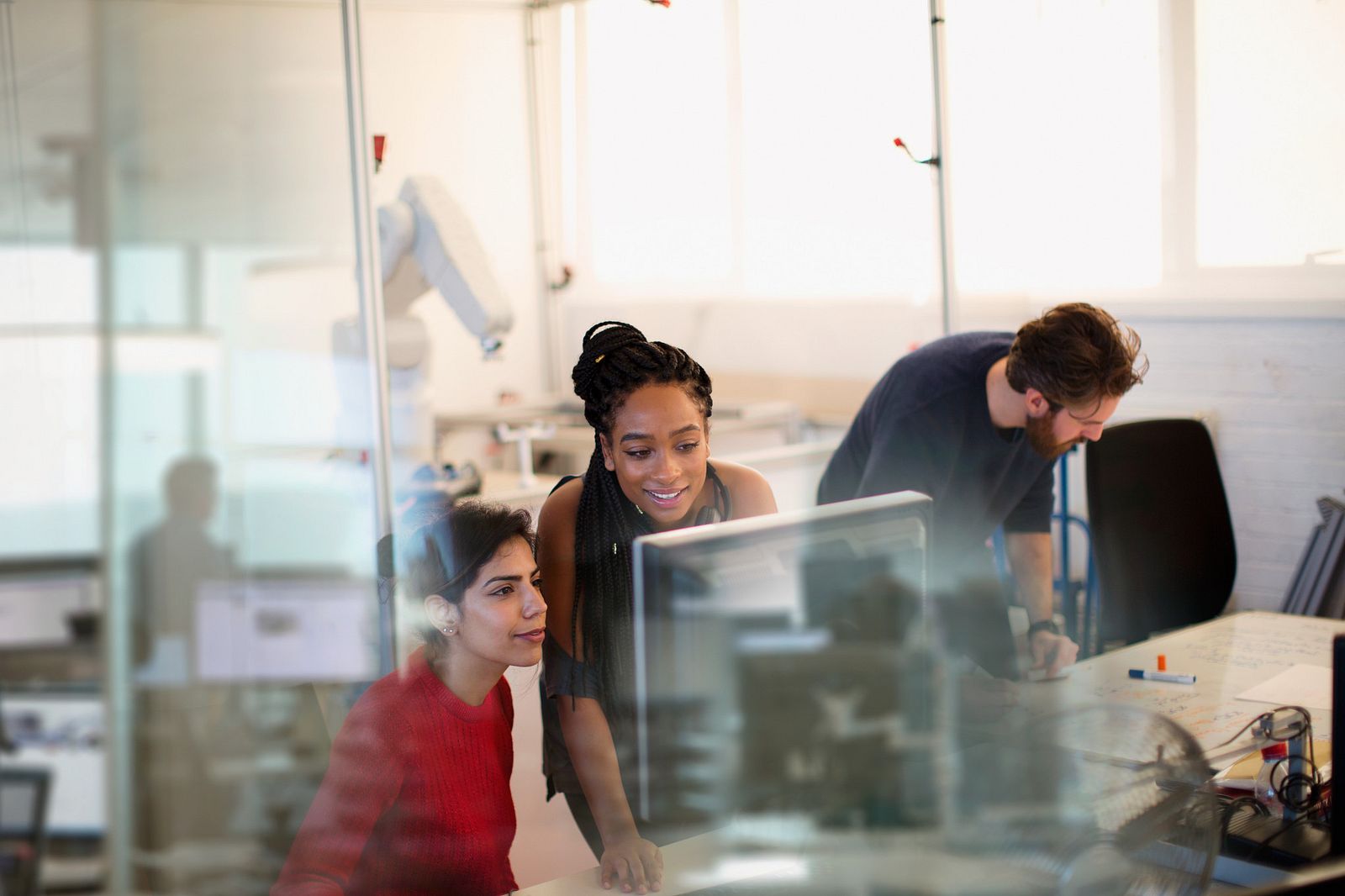 two female professionals working together on a desktop computer