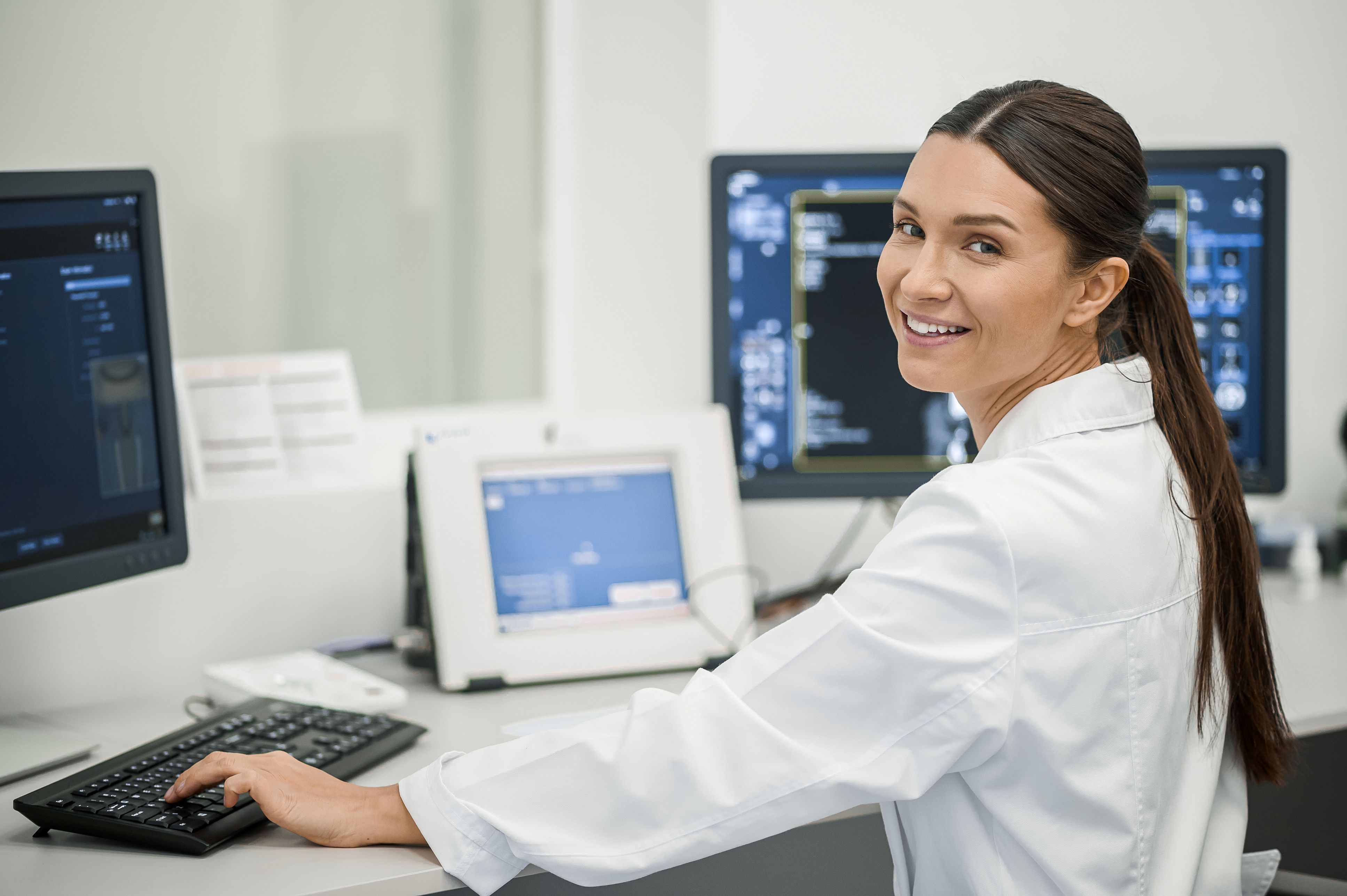medical professional at desk within multiple screens representing medical device manufacturers and supply chain