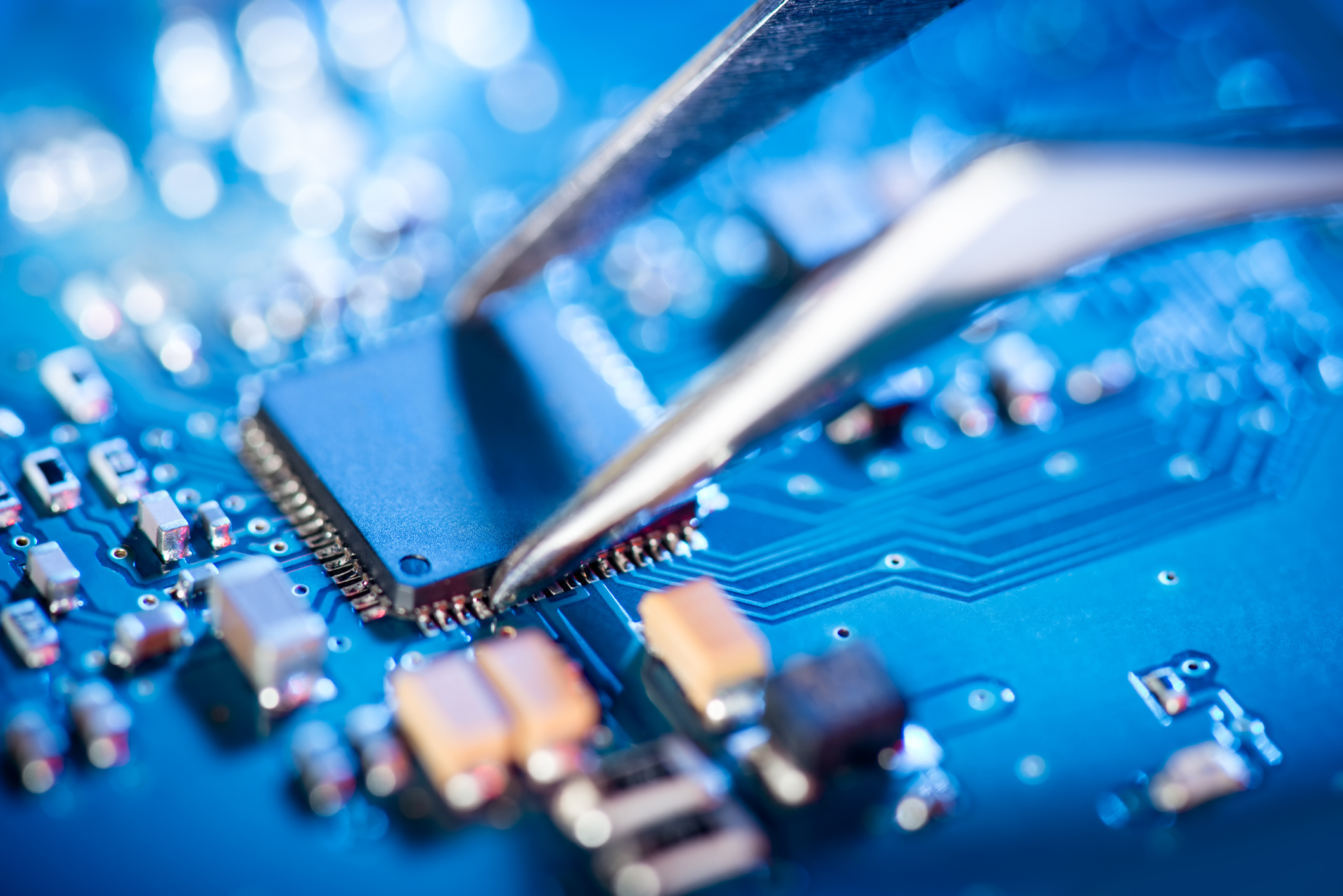 a circuit board for a medical device is having a chip placed by a pair of tweezers